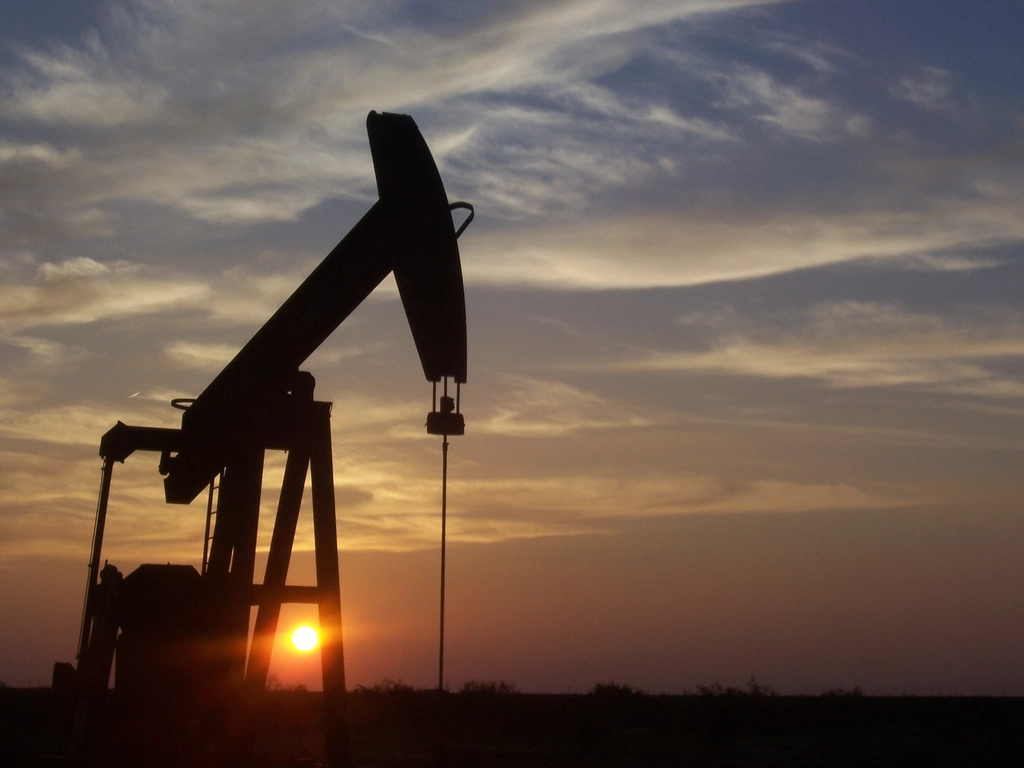 Oil pumpjacks operating in a field at dusk